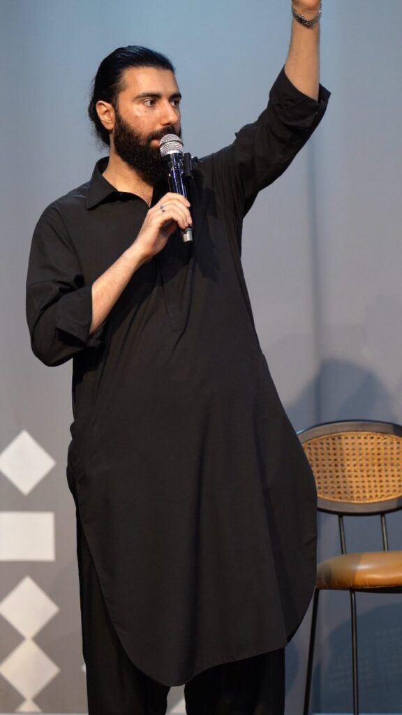 A speaker raising a hand while addressing the room