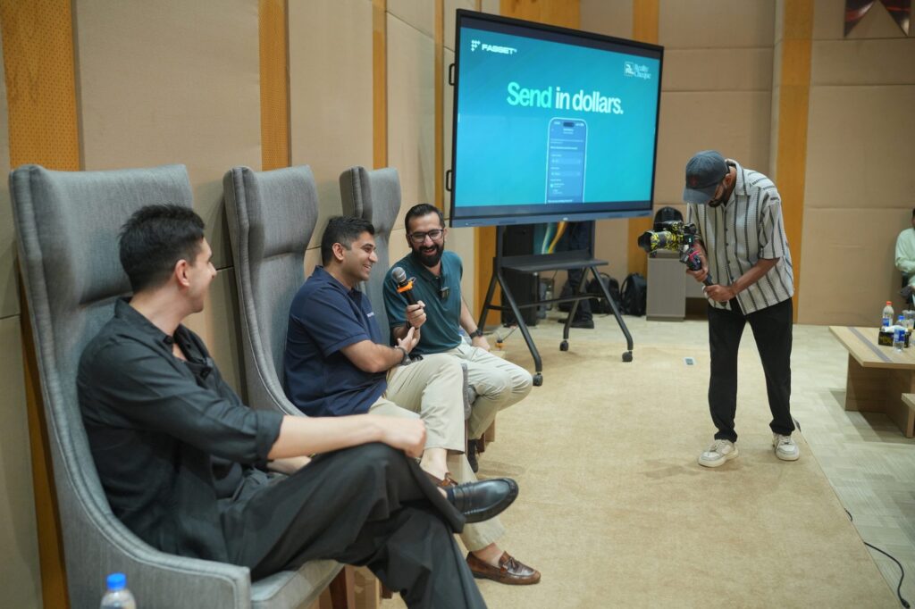 A speaker walking the floor in front of the panel chairs