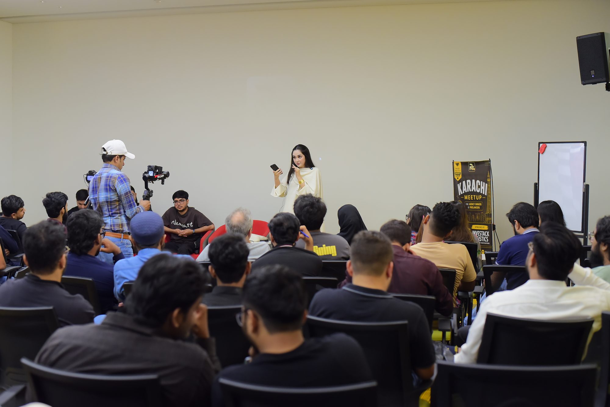 A speaker with a microphone addressing the Karachi room