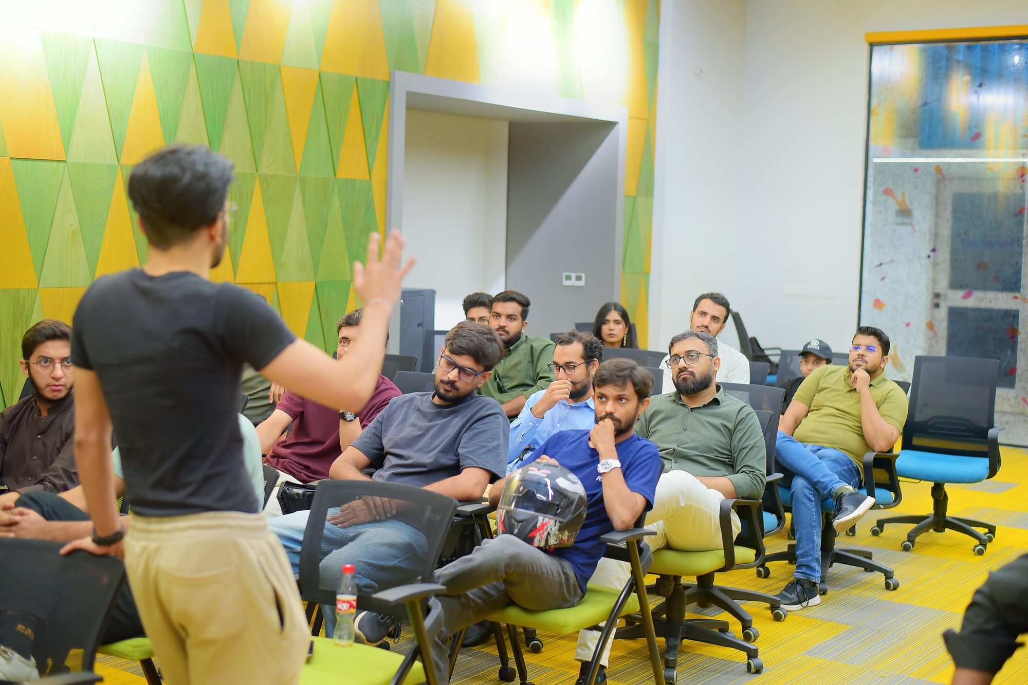A host talking with attendees seated in a circle in Karachi