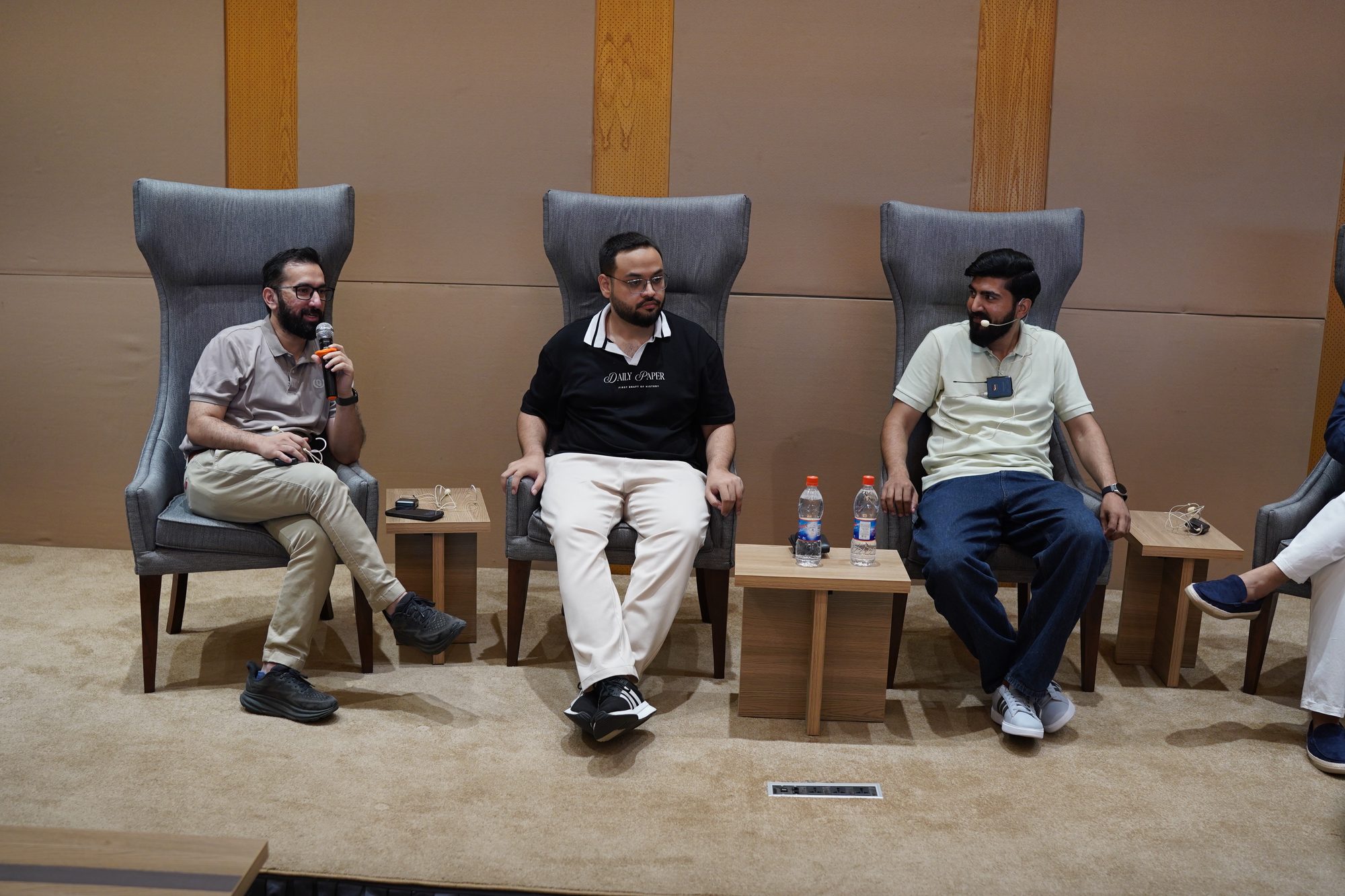 Three panelists seated at the front in Lahore