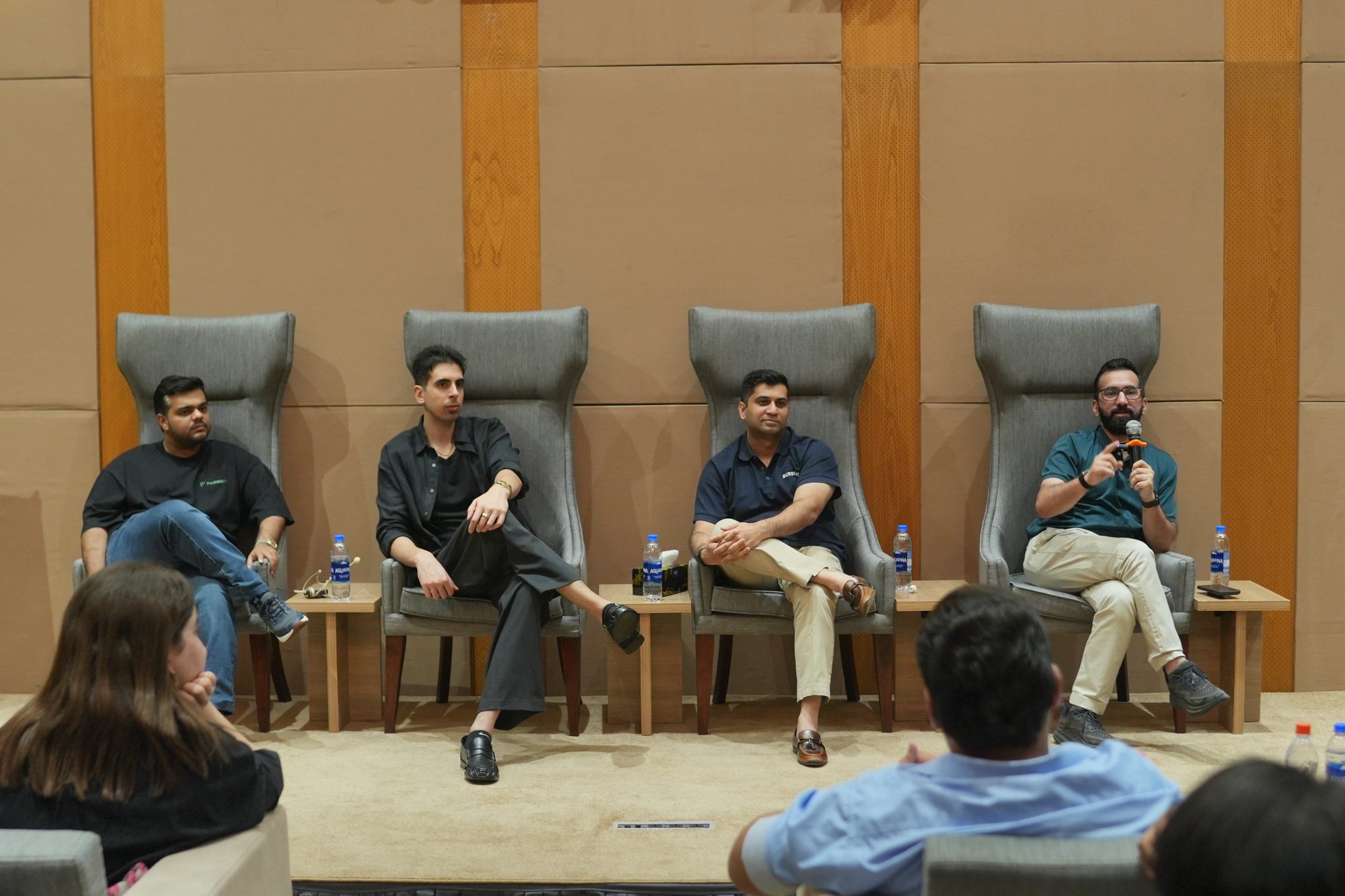 Four panelists seated at the front of the room