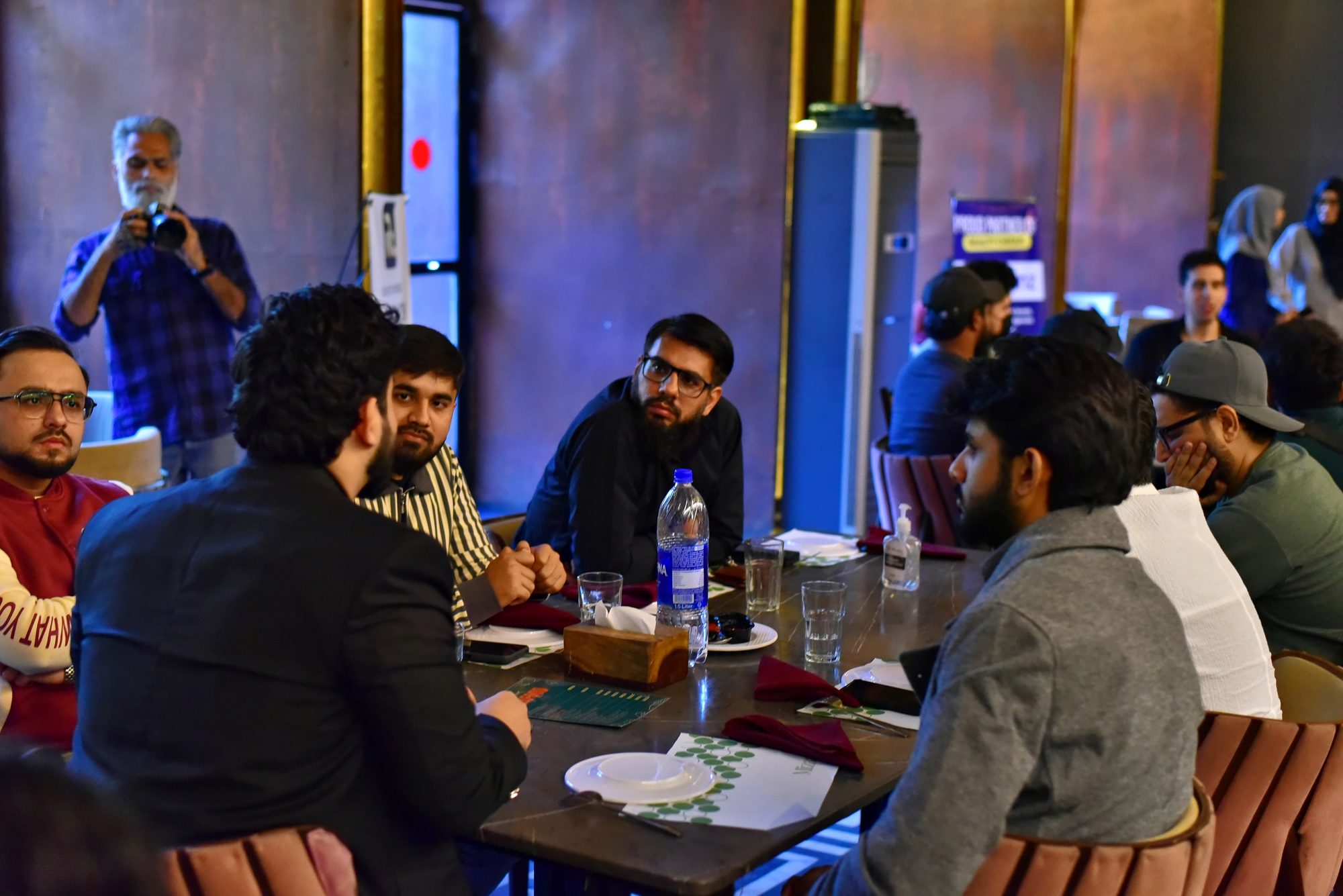 Attendees talking around a table during the roundtables